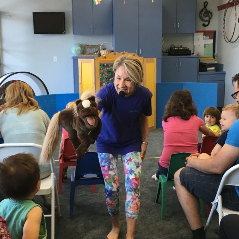 Teacher Lynn tells stories with puppets to children